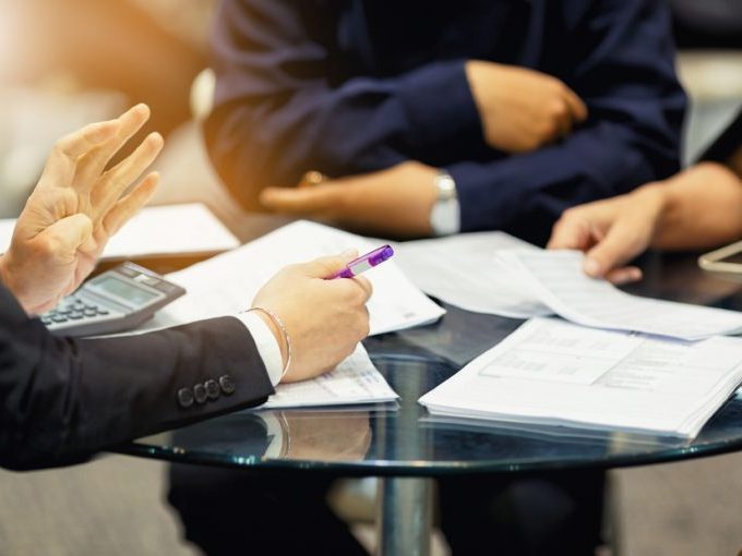 ABOGADOS Y ASESORÍA LABORAL EN ZARAGOZA Y HUESCA. Imagen de una reunión de abogados con empresarios y papeles ensobre una mesa.